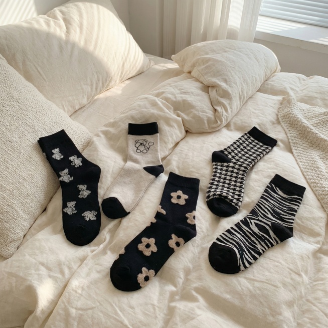 把图中的袜子换一个场景，场景在床上，随意的摆放，场景真实，生成3张图片预览效果