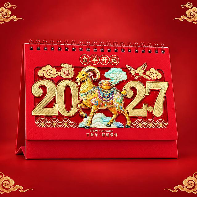 从这张四宫格图中提取右上的金羊开运款台历，单独生成一张选品图。严格保留台历封面原始设计：顶部圆形印章'金羊开运'四字、中央金羊驮宝珐琅彩造型（金羊、元宝、祥云、蝴蝶）、两侧镂空金色2027数字、底部波浪纹装饰、'NEW Calendar 丁癸年·好运常伴'小字、红色线圈、红色三角底座，所有细节不做任何改动。背景为纯净中国红渐变，四角点缀少量金色祥云纹样，台历居中放置，占画面约70%，正面微仰视角度，整体高端国潮风格。