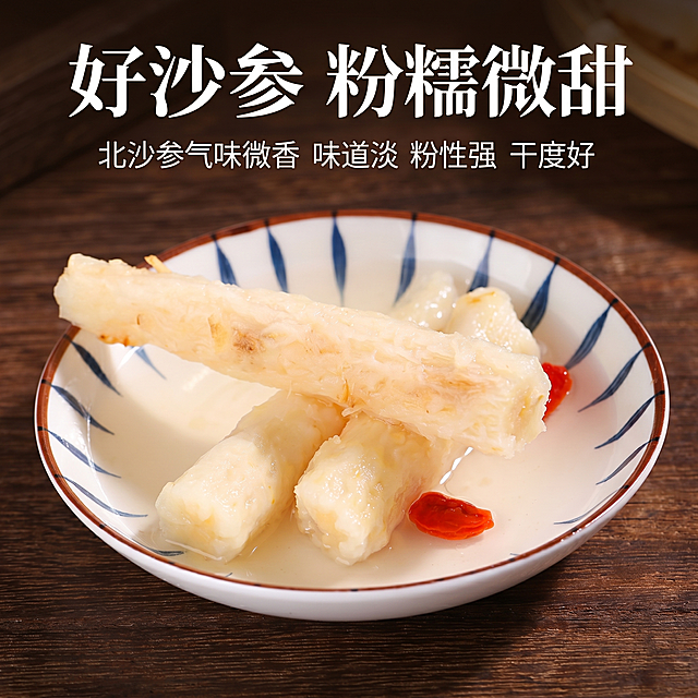[主图 5] 北沙参炖煮后口感展示，突出粉糯微甜特点。
[氛围风格] 食欲感，真实食用场景。
[画质] 商业摄影质感、光线柔和通透、产品清晰真实、画面干净高级，保持北沙参外观与输入产品图一致，杜绝任何变形和色差，精细化处理。
[元素] 炖煮好的北沙参段摆放在带有蓝红纹饰的白瓷盘子中，搭配几颗枸杞子点缀，放在深棕色木质桌面上，展示炖煮后粉糯饱满的状态。商品主体占比约70%，清晰展示北沙参煲汤后的形态。
[光影] 自然暖光，突出汤汁通透感和北沙参粉糯质地，整体温暖有食欲。
[配色] 深棕色木质底，搭配白瓷盘和淡黄色北沙参、红色枸杞，色彩自然协调，文字对比清晰。
[视角构图] 平视俯视结合，主体居中，满屏无边框。
[文字版式] 顶部大字标题"好沙参 粉糯微甜"白色粗体，下方小字文案"北沙参气味微香 味道淡 粉性强 干度好"白色字体，排版风格字体颜色和全套主图保持一致，整体统一协调。
[比例分辨率] 1:1 比例，2k 分辨率；文字清晰可辨，超高清。
[负向提示词] 变形，水印，文字错乱，产品图模糊，背景杂乱
