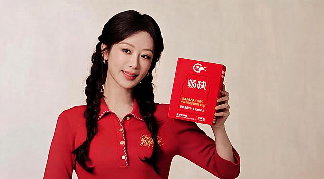 把图一模特手持的产品替换成图二的优益C畅快红色包装盒产品，保持清晰度高，自然光线效果，保持模特面部表情动作与场景不修改，保持皮肤的自然感，光影和整体风格和原图保持一致，不要修改其他区域内容