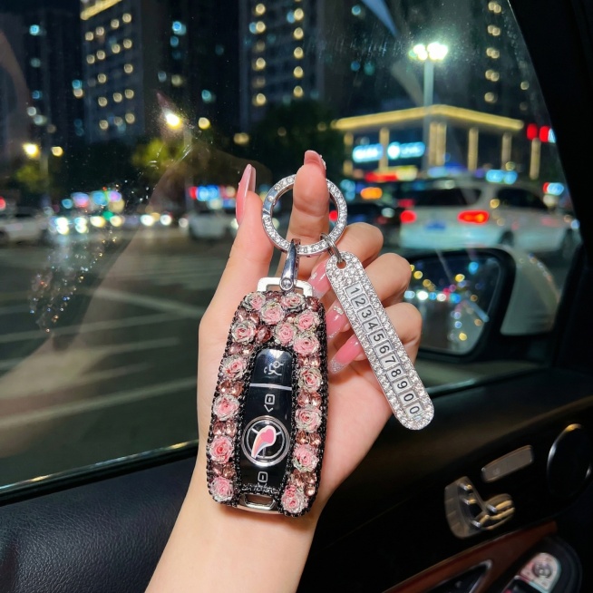 将背景改成车内拍摄效果，车外为大都市大街上虚化夜景，把手修改为修长有长指甲的手，保持车钥匙套细节不变预览效果