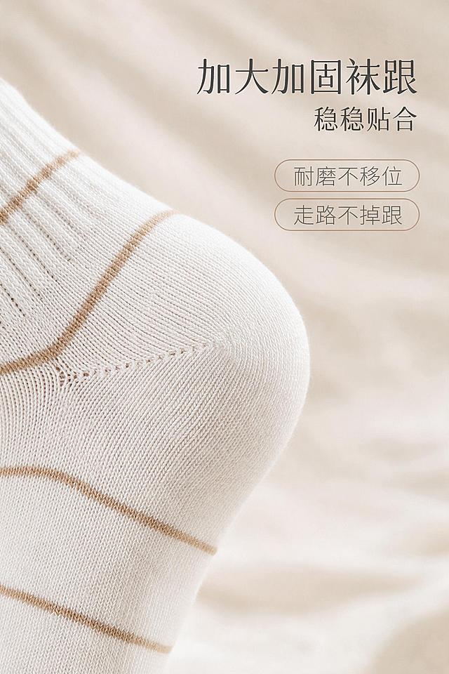 [商品] 使用【图1】米白浅棕条纹短袜；商品处理：100%继承原袜子的针织面料、纱线纹理、织物颗粒、原有条纹印花、褶皱、明暗光影，袜子质感完全复刻原图，禁止重新生成袜子材质，不抹平颗粒，不要塑料光滑感；仅适配环境光影，袜子本身纹路细节不做美化、不过度修图，保持真实实拍纪实质感。重点展示袜跟部位，保留加固结构、织纹走向、条纹衔接。
[画面] 页面目标：袜跟细节展示，突出加大加固不掉跟。画面为袜跟部位特写放大，清晰展示袜跟的Y型加固织法、立体剪裁和耐磨结构，可搭配侧面视角展示贴合脚跟的弧度。背景为浅米色柔焦虚化，袜跟位于画面中心偏左，右侧留白放文案。整体突出稳固贴合、耐磨不移位的品质感。
[视觉] 套系策略：风格=真实实拍纪实质感，高级简约商业摄影；标题字=现代简约无衬线粗体；正文字=简洁无衬线体；主色=米白奶杏色；背景延展=基于米白奶杏做深浅层级、同色渐变和细腻织物/纸张质感；强调色=浅驼棕，仅用于小面积图标、引线和标签；标题色=深炭灰；正文色=中暖灰；组件=细线引线、浅底圆角信息卡；光影=左前侧自然柔光，柔和漫反射，真实阴影。
[文字] 右侧主标题"加大加固袜跟"，副标题"稳稳贴合"，下方两个卖点："耐磨不移位"、"走路不掉跟"。文字全部横向排版，层级分明，不遮挡袜跟细节主体。
[规格] 图片比例2:3竖版，2K分辨率，真实实拍纪实质感，不过度修图。避免袜子材质改变、纹理抹平、塑料光滑感、变形、错字、文字过小、冷蓝/蓝灰背景。