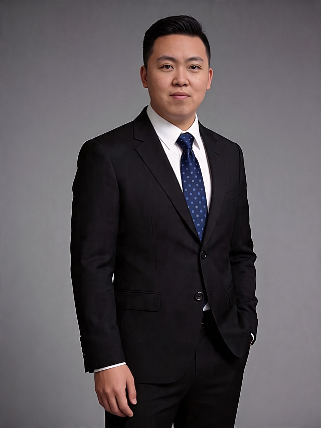 仅将人物的眼睛修改为双眼皮，其他部分保持原样不变，保留原本的西装、灰色背景、人物姿态和整体色调