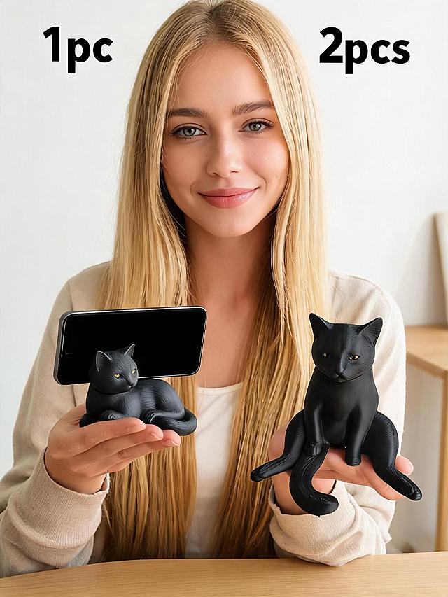 金发外国美女手持展示黑色小猫造型手机支架，家居简约桌面场景，标注文字2pcs/1pc，跨境电商风格，产品造型保持原样不变