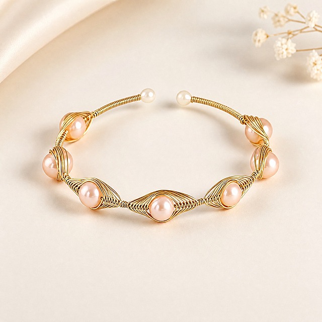 AliExpress main image 1, premium jewelry product photo. Freshwater pearl gold wire-wrapped open bangle bracelet. Creamy white soft gradient background, pure and elegant. Bracelet centered in frame, slightly angled to show both the front pearl details and the open ends with small pearls. Seven lustrous pinkish freshwater pearls set in intricate hand-wrapped gold wire eye-shaped settings. Gold wire has smooth polished finish, pearls have natural iridescent luster. Soft studio lighting from upper left, gentle highlights on pearl surfaces and gold wire edges. Subtle contact shadow beneath bracelet. No text, no logos, no watermarks. Clean minimalist composition, product takes about 70% of frame. 1:1 square ratio, ultra sharp details, professional jewelry photography quality.