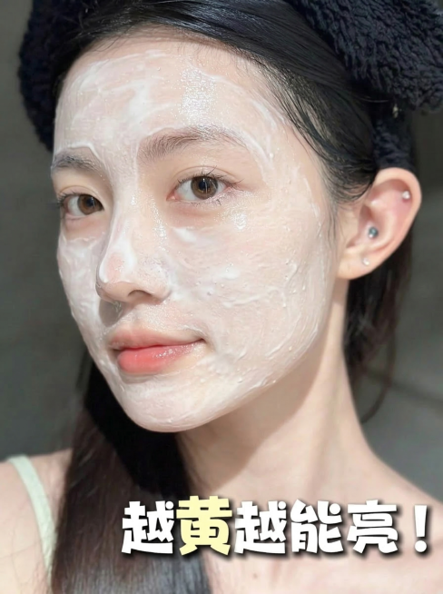 保留图中人物的发型、妆容、表情和姿态不变，将脸上的片状面膜替换为白色酸奶质地的涂抹式面膜，面膜质地为水润乳霜状，均匀覆盖在脸颊、额头和下巴区域，带有细腻的水光反光，看起来像刚敷上的焕亮面膜，整体色调保预览效果