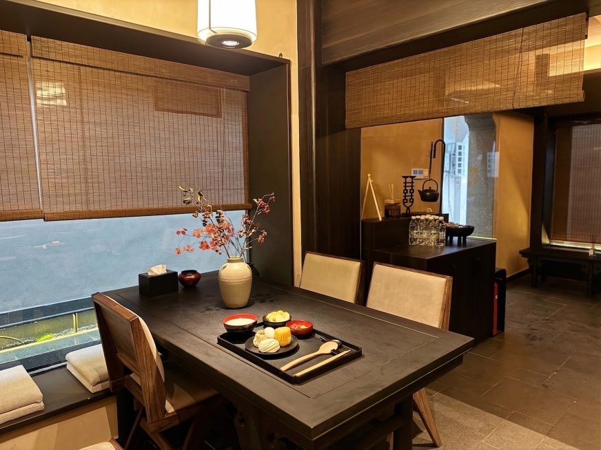 在黑色餐桌的空闲位置放置一个中式简约花瓶，保持原有房间新中式风格和其他元素不变，整体协调自然预览效果