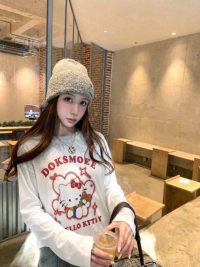 将图5的Hello Kitty白灰渐变宽松长袖T恤穿到图1模特身上，衣服版型为宽松版型，衣服的花色、图案、纹理、面料严格复刻参考服装，真实人像摄影，自然光，皮肤质感真实，高清，写实，柔和环境光影，衣服贴合身体，服装褶皱自然，无水印，无文字，无logo，无畸形肢体，画面干净，不要改变人物长相，保持原图的背景、姿势、配饰和整体构图不变