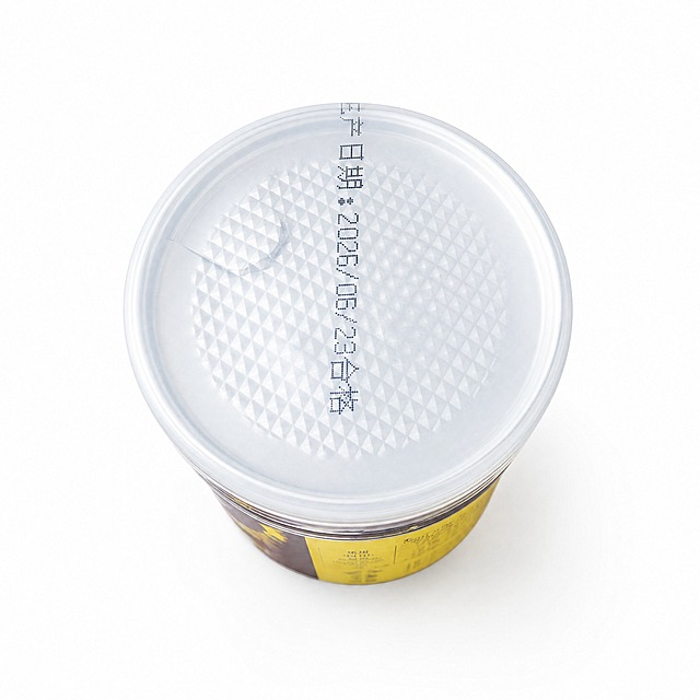产品精修，产品置于纯白背景上，专业商业棚拍光，5500K标准中性白光，轮廓光，体积光，曝光正确，强烈真实立体感，净化杂乱倒影、脏反射、环境色污染和黑块反射，金属重建干净棚拍高光条带，透明材质保留真实折射与透明层次，接地处保留干净浅淡的自然接触阴影，严禁大片投影、脏灰阴影和悬浮感，主体居中，商品完整入画不裁切，商品外轮廓视觉体量约画面60%-80%，四边均匀留白约10%-20%，严禁满幅铺满与贴边顶满，极致超清画质，细节清晰锐利，4K分辨率，商业级实拍质感，保留原图真实材质与结构细节，明显提升商品表面洁净度，清理灰尘、污渍、指纹、油污、胶痕和霉点，让表面从脏旧发闷变为干净可售卖状态，修复划痕、磨损、掉漆、飞边毛刺和使用旧痕，翻新为干净商业新品感，基于原图材质恢复纹理、颗粒、折射、高光、柔韧折痕、透明边线或工艺细节，避免糊成塑料感，去除非售卖主体杂物、临时垫块、包装垫、支撑块、纸片或填充物，严禁误删商品结构，锁定原图商品颜色，颜色以输入图为唯一参考，分段部件颜色边界按原图锁定，还原真实物理色彩，消除灰暗感和偏色，锁定原图商品轮廓、件数、部件位置、连接关系、标签文字和可见功能细节，只做精修不重绘结构，瓶盖、喷码结构与原图一致，禁止改变盖型或喷码内容，锁定原图材质表现，保持原有质感、光泽、纹理和色相关系，透明瓶盖：透明塑胶/亚克力/PC质感，折射边线清晰，透明层次自然，铝箔封口：金属肌理质感，保留压纹与哑光金属观感，正视图（俯视顶部生产日期），严格保持原图透视，严禁扶正，严禁镜像翻转，比例1:1