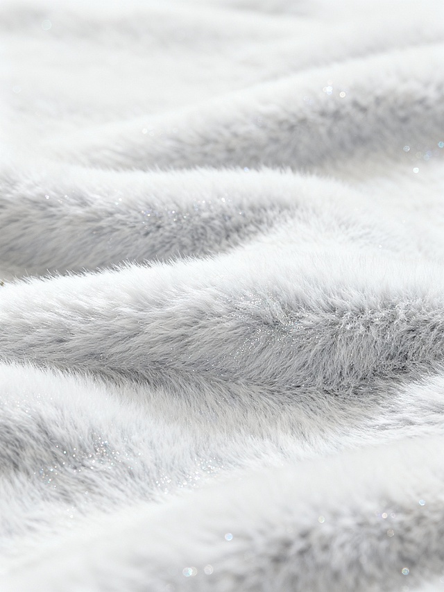 一张以纯净的白色和浅灰色为主色调的毛绒材质背景图，整体呈现出柔和细腻的质感，如同被细密绒毛覆盖的表面，带有轻微的波浪状纹理起伏，局部点缀着细碎的闪光颗粒，营造出宁静而精致的氛围，背景设计简约大方，没有多余元素干扰，光线柔和均匀地洒在毛绒表面，凸显出材质的柔软与温暖。