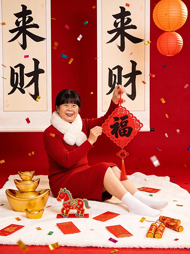 喜庆红金配色，剪纸风“福”字与鎏金元宝呼应，刺绣马饰点缀国潮元素，中式春联与灯笼营造浓厚年味，展现传统与现代交融的民族节日氛围。