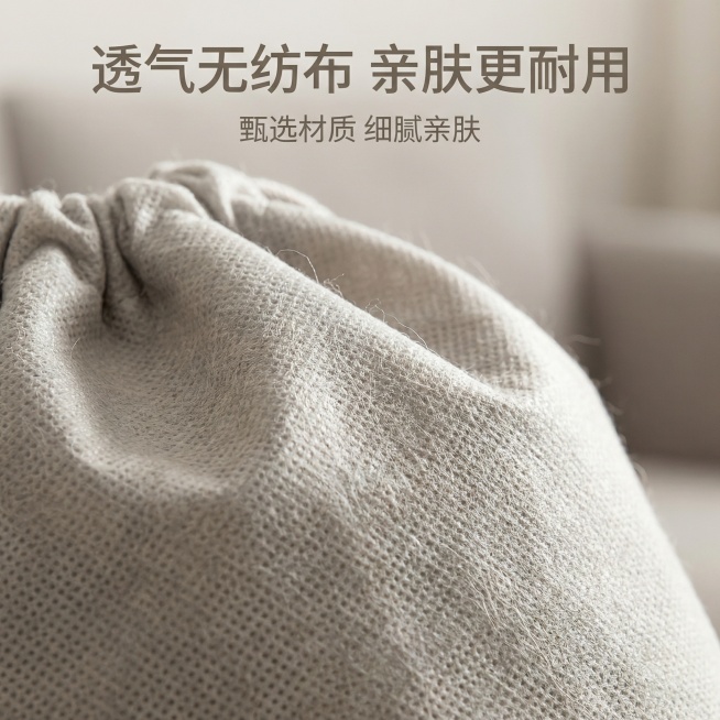 微距放大展示无纺布束口袋的布料纹理，突出无纺布材质透气耐用的特性，浅暖灰色背景侧逆光拍摄，呈现布料清晰纤维纹理，画面中心是放大的布料细节。顶部主标题“透气无纺布 亲肤更耐用”，下方标注文字“甄选材质预览效果