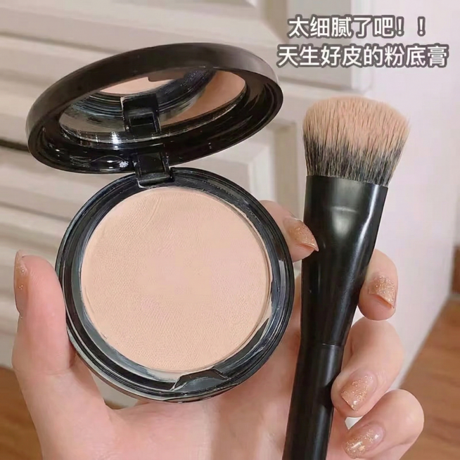 生成和参考图风格一致的实拍风图片，第一视角手持圆形开盖粉底膏和黑色化妆刷，背景为浅米色家居场景，右上角配文字“太细腻了吧！！天生好皮的粉底膏”，画面真实有生活感，粉底膏质地细腻自然预览效果