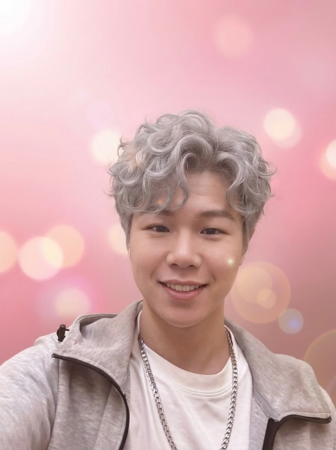 修改为偶像剧男主风格，背景为虚化光斑+粉色渐变，调整嘴角上扬弧度更大保持温暖微笑，整体调整为偏粉棕的柔和马卡龙色调，让发丝呈现自然卷度更蓬松，调整眼神更温柔专注预览效果