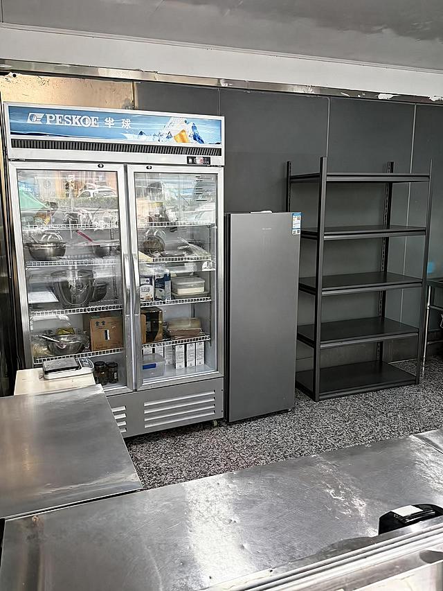 去除右侧5层金属货架上的所有物品（包括篮子、锅、塑料盒、纸箱、包装袋等所有摆放在货架上的物品），仅保留空的货架主体结构，货架的金属框架和层板完整保留。严格保持房间内其他所有主体、细节、结构、颜色、光线、透视角度完全不变，不得添加或修改任何其他元素。去除物品后的区域用周围真实的墙面、地面和货架结构自然填充，光影和材质与原图一致，过渡自然无痕。最后整体提升图片清晰度，画质自然真实，保持原照片的真实感。处理效果与同场景另一角度照片保持一致。