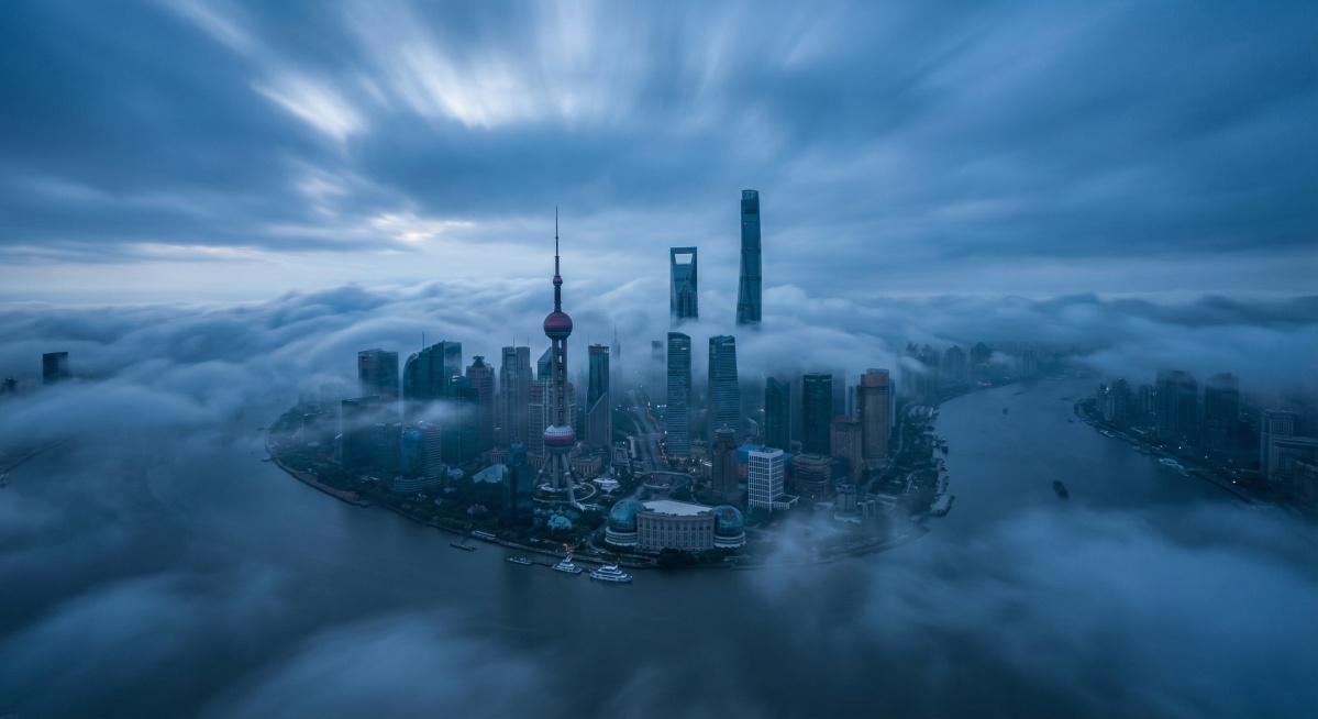 电影级广角航拍，上海陆家嘴与黄浦江的全景俯瞰，摩天大楼群如岛屿般浮现在厚重、阴郁的蓝色云海之上。清晨冷色调，神秘氛围。云雾流动的延时摄影效果。柔和的漫射光，无直射阳光。超写实，8k分辨率，孤独与宏大感预览效果