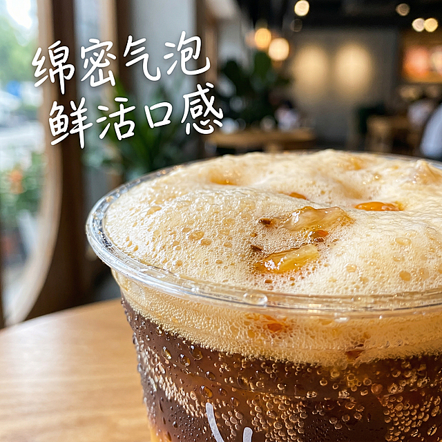 沙棘气泡美式细节特写主图，瑞幸产品海报风格，小红书氛围感。微距特写杯口绵密气泡和沙棘果肉颗粒，清晰展示果汁气泡的细腻质感，杯壁挂着透亮水珠，背景虚化突出主体。主标题 "绵密气泡 鲜活口感"，字体采用清新手写体，悬浮在画面左上角留白处，整体光影通透，放大诱人细节，呈现清爽质感。