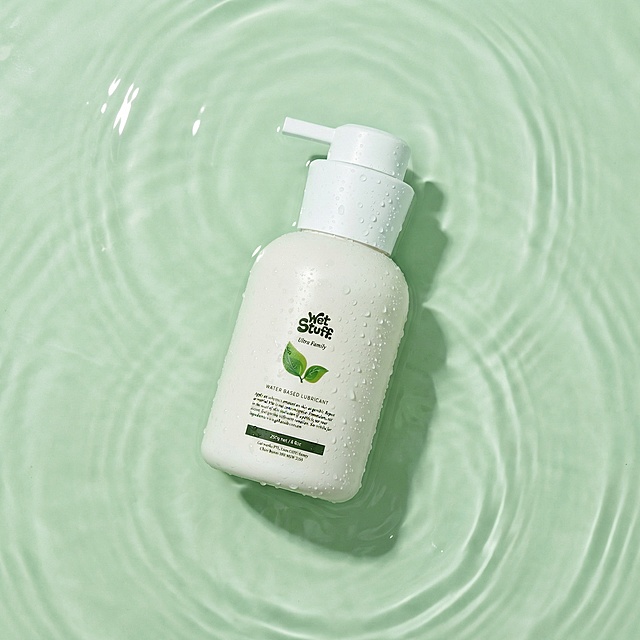 将产品处理为平铺躺在水面的俯拍视角，水面有淡淡的水纹，产品瓶子表面添加一点点水珠，整体调整为淡绿色色调