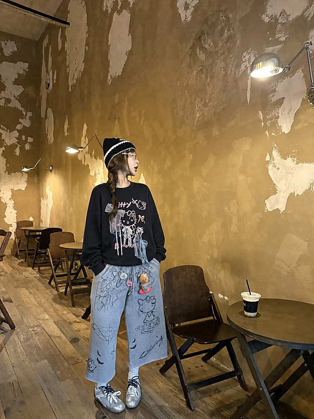 将图1中的黑色Hello Kitty蝴蝶结装饰宽松卫衣穿到图2的模特身上，保留模特原有的五官、脸型、发型、帽子、眼镜、姿势、身体姿态、裤子、鞋子和背景环境完全不变。卫衣为宽松版型，衣服的花色、粉色Hello Kitty图案、各色蝴蝶结装饰（纱质蝴蝶结、蕾丝蝴蝶结、小蝴蝶结）、面料纹理严格复刻图1参考服装。真实人像摄影，自然光，皮肤质感真实，高清写实，柔和环境光影，衣服贴合身体，服装褶皱自然，无水印，无文字，无logo，无畸形肢体，画面干净，不改变人物长相。