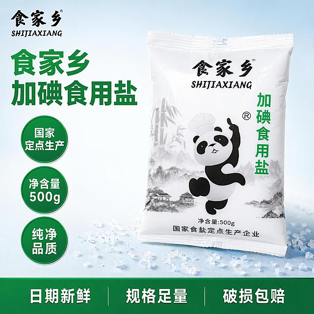 [单张主图] 食家乡加碘食用盐，爆款促销感主图，用于直播间商品展示，满足点击理解信任转化全链路需求。
[画面主体] 保持产品外包装、品牌标识、熊猫图案、文字信息与输入产品图完全一致，不修改产品外观、颜色、结构。产品包装袋居中斜置摆放，占画面约60%，完整展示产品全貌无裁切，品牌Logo放置在画面左上角安全区。
[构图版式] 采用左文右品标签参数型版式，左侧35%区域放置标题和卖点，右侧放置产品主体，底部设置服务信息条。
[场景元素] 背景使用浅蓝到白色渐变干净留白，左侧搭配简约圆形标签突出核心卖点，底部用深绿色半透明通栏放置服务承诺，不遮挡产品主体。搭配少量晶莹盐粒作为装饰点缀在产品周围，增加产品真实感。
[文案版式] 左上区域：大标题 "食家乡
加碘食用盐"，粗黑体绿色最大字号，分两行左对齐；向下依次排列三个卖点标签：圆形绿色标签配白色文字 "国家定点生产"，圆形绿色标签配白色文字 "净含量500g"，圆形绿色标签配白色文字 "纯净品质"。底部深绿色通栏：白色文字排列服务卖点 "日期新鲜 规格足量 破损包赔"，均匀分布。
[光影质感] 主光源为正面柔光，均匀照亮产品包装，突出包装印刷清晰度；辅以侧面轮廓光，增加产品立体感，背景有轻微渐变光影过渡，整体画面干净通透，商业摄影超清质感。
[配色字体] 主色调白色和产品包装绿色，辅助色浅蓝和深绿，强调色产品包装深绿色。字体使用粗黑体，大标题字号最大，卖点标签字号适中，底部通栏文字字号最小，对比清晰。
[比例分辨率] 1:1比例，800*800像素，2K分辨率，文字清晰可辨，所有文字无遮挡可读。
[负向提示词] 变形，文字错乱，产品模糊，背景杂乱，水印，电商平台Logo，错字，伪Logo，主体遮挡，低清晰度