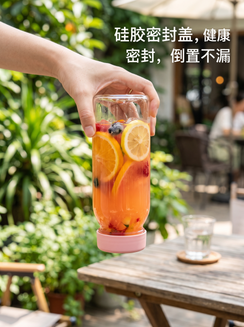 倒置的粉色硅胶盖高硼硅玻璃冷泡茶杯，杯口朝下不漏水，杯内装有果汁，展示产品超强密封性能，清爽风格，文字文案：'硅胶密封盖，健康密封，倒置不漏'，整体画面清新吸引人，3:4比例预览效果