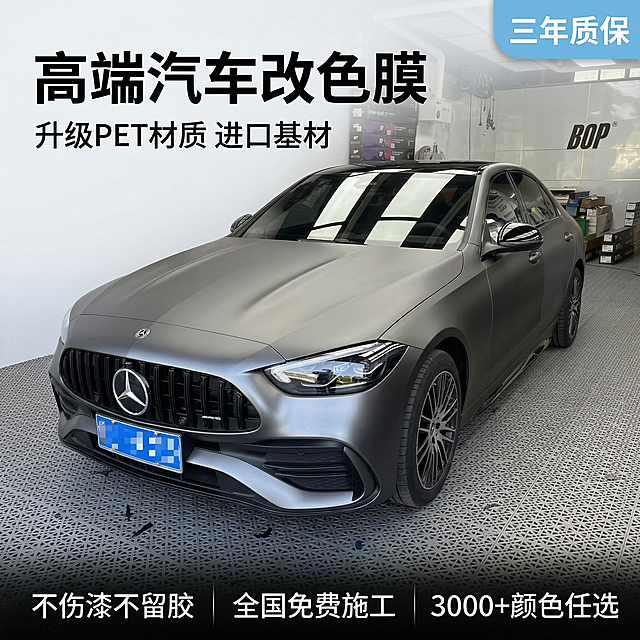 垫图为用户提供的第一张哑光灰奔驰改色实拍图，主题为专业汽车改色膜改色效果首图，氛围为高端专业汽车美容风格，质感出众画面干净高级。画面元素：改色后的哑光灰奔驰居中展示，占画面50%-70%，专业施工车间背景整洁干净，光线均匀柔和突出改色膜的细腻哑光质感，背景铺满全屏无边框。配色色系：主色调为车辆的金属哑光灰，辅助色为车间的浅灰和白色，整体配色高级简约。视角构图：平视车头45度角，景深适中，突出车辆整体改色效果。文字版式：左上角大字号粗体无衬线黑字 "高端汽车改色膜"，副标题小字 "升级PET材质 进口基材"，右上角浅蓝色圆角标签 "三年质保"，底部半透明渐变蒙层，三列白色卖点文字 "不伤漆不留胶 全国免费施工 3000+颜色任选"，文字不遮挡车辆主体，整体构图平衡清晰。