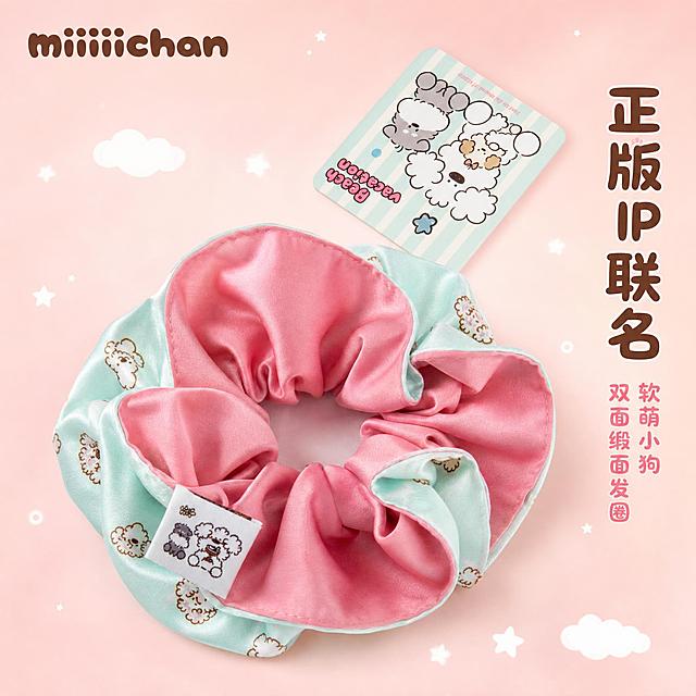 [主图-1] 首图点击率，展示miiiiichan正版IP联名软萌小狗双面缎面大肠发圈的整体颜值与治愈系氛围。
[统一基调] 整体风格软萌复古童趣治愈系，马卡龙薄荷绿+樱花粉主色调，背景为柔和渐变的奶油粉色，点缀细碎的白色小星星和小云朵插画元素，字体使用圆润可爱的卡通圆体，标题字色为深棕色，辅助字色为浅粉色，整体氛围甜美治愈充满少女心。
[画面] 发圈主体居中偏下位置，占画面约60%，以微俯视角度展示，完整呈现双面双色设计——外侧是薄荷绿底满印白色卷毛小狗图案，内侧是樱花粉纯色缎面，发圈自然堆叠成饱满的花朵形态，品牌布标清晰可见位于左下方。发圈右上方悬浮一张同系列IP小卡片，卡片上有两只可爱小狗插画和"Beach vacation"字样，与产品图案呼应。背景为柔和的奶油粉色渐变，散落着几颗迷你白色小星星和小云朵装饰，营造童趣氛围。左上角放置miiiiichan品牌Logo（圆润可爱的字体风格）。
[光影质感] 柔和的漫射光，缎面材质呈现丝滑的光泽感，褶皱处有自然的明暗过渡，发圈底部有淡淡的投影，整体干净通透，商业摄影质感。
[配色] 主色薄荷绿、樱花粉，背景奶油粉，文字深棕色，点缀白色小星星小云朵。
[文字版式] 左上角品牌名"miiiiichan"用圆润卡通字体，深棕色；画面右侧竖排主标题"正版IP联名"用稍大的圆体字，深棕色；下方小字"软萌小狗 双面缎面发圈"用浅粉色圆体字。文字都放在负空间，不遮挡产品主体。
[输出要求] 1:1正方形，产品清晰，文字清晰可读，色彩柔和治愈。负向：变形、错字、模糊、杂乱、水印、平台Logo、塑料感、廉价感、发圈形状扭曲。