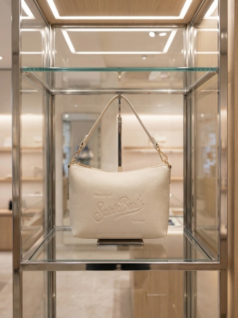 图中包包自然挂在在展柜中，有玻璃隔开，突出产品预览效果