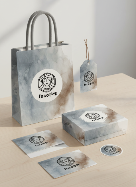 参考这个LOGO，做一套艺术手作品牌视觉设计，品牌名称为“Foco手作"，包括包装袋， 吊牌，纸盒，感谢卡，贴纸等。灰、蓝、棕晕染，艺术感强。预览效果