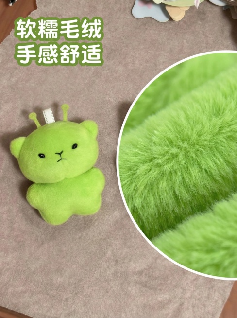 [主图 3 细节展示] 放大展示绿色毛绒外星小熊挂件的毛绒材质细节，用微距特写展示绒毛柔软蓬松质感。左侧是整体挂件，右侧放置放大的绒毛局部细节小图，拼图设计。背景为浅米色绒布，整体风格柔和，光影自然，预览效果