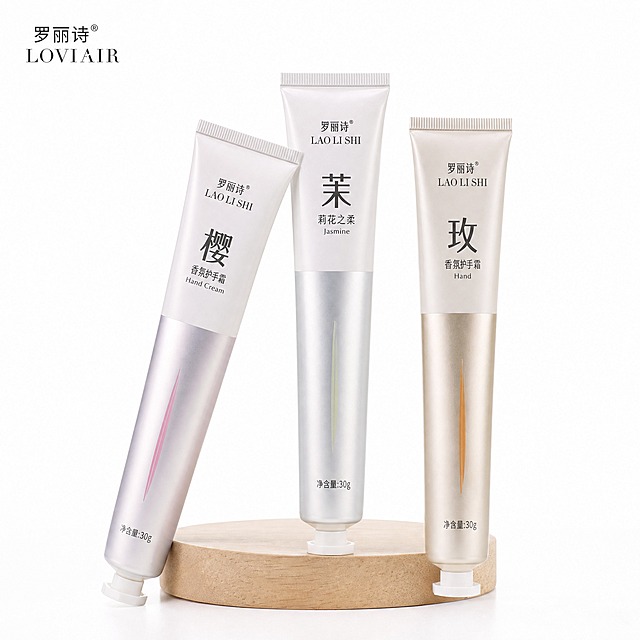 [主图-1] 3-Pack Floral Hand Cream Set (Cherry Blossom / Jasmine / Rose) 首图，纯白底产品展示。
[统一基调] 纯净植萃高级感，奶油白+柔粉+香槟金主色，柔光自然窗光，主标题用干净非衬线粗体字，辅助文字用同系列细体，标题字色深灰近黑，辅助字色中灰，强调色柔粉，卡片与图标用极细描边+浅底圆角，整体克制高级。
[画面] 纯白背景，三支护手霜管身从左到右依次为樱花款（粉银管）、茉莉款（银白管）、玫瑰款（金铜管），呈扇形微微倾斜站立在浅米色圆形木质小展台上，产品完整不切割，占画面约85%。左上角放置同款品牌Logo（LOVIAIR），小号精致排版。管身印刷文字与原图一致，不改变外观、颜色、材质和比例。底部有柔和接触阴影，无悬浮感。
[光影质感] 高级静物商业摄影质感，柔光箱主光从左上45度打下，右侧柔和补光，管身呈现细腻金属哑光反光，底部投影自然虚化，整体通透干净。
[配色] 纯白背景，产品本身的粉、银、金铜色为主视觉，无多余色块。
[文字版式] 首图为Amazon白底主图，除产品本体印刷文字与左上角品牌Logo外，不添加任何额外标题、卖点文字或装饰元素，符合Amazon首图规范。
[输出要求] 比例1:1，产品清晰锐利，文字印刷清晰可辨，无变形、错字、模糊、杂乱、水印、平台Logo。