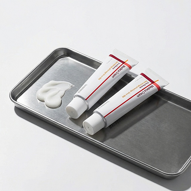 根据图中产品再结合一下提示词生成八张不一样的产品图- 专业院线风：产品置于浅灰色医美级背景上，管身倾斜45°，突出“Dermatological Heritage Since 1968”字样，冷调柔和光线，营造专业、安心的护肤氛围。右侧排列三枚认证徽章，整体构图简洁有力，突出医学护肤与抗衰修护卖点。       2. 氛围感场景图（社交种草+代入感）   - 夜间修护场景：Centellian24抗衰面霜放在木质床头柜上，旁边搭配同品牌精华、香薰蜡烛与暖黄小夜灯。手取面霜轻抹在手背，柔焦暖光营造治愈氛围，突出夜间抗衰修护的仪式感。背景点缀积雪草叶片（呼应成分），强化产品天然修护力。 - 极简ins风护肤台：白色软管面霜置于米白色大理石台面上，搭配透明玻璃杯与新鲜积雪草，自然光柔和洒落，整体色调干净柔和。管身红橙线条成为视觉亮点，突出产品温和抗衰、适合敏感肌的特点，画面松弛治愈。       3. 成分与质地图（放大核心卖点）   - 质地特写：白色软管挤出绵密乳霜质地，指尖推开后呈现水润光泽，柔光捕捉细腻肌理，背景为纯净浅灰。特写积雪草叶片与面霜同框，突出产品修护抗衰的核心成分，画面干净有说服力。 - 成分可视化：面霜质地特写，周围环绕半透明积雪草活性分子特效，冷光背景下凸显成分活性与修护力。软管包装一角入镜，强化品牌识别，适合突出科技抗衰的内容场景。