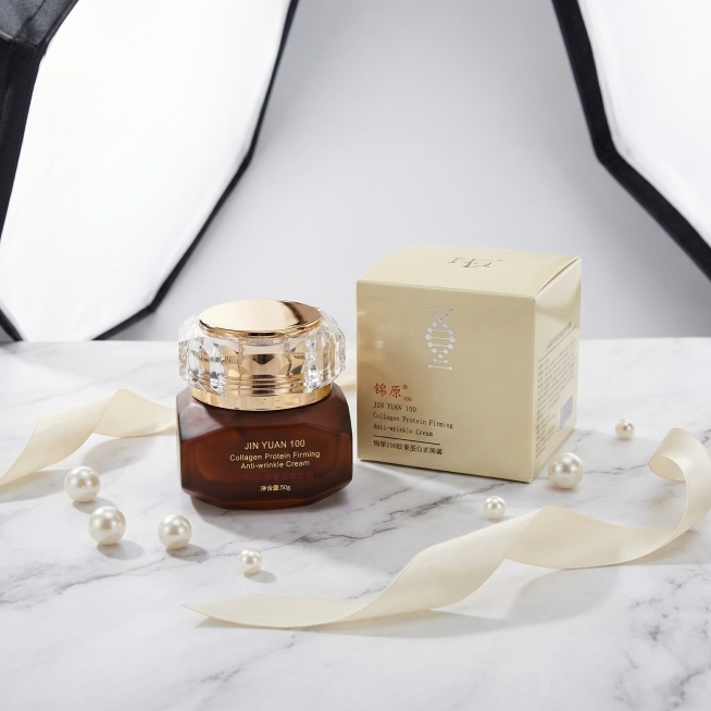 将护肤品膏体瓶和包装盒两个主体自然组合，搭配轻奢优雅风美妆场景，大理石台面，周围点缀珍珠、丝带，柔光箱漫射光，整体明亮通透，保持产品上的文字和Logo原样，保持主体物理结构不变，添加柔和的接触阴影，符预览效果