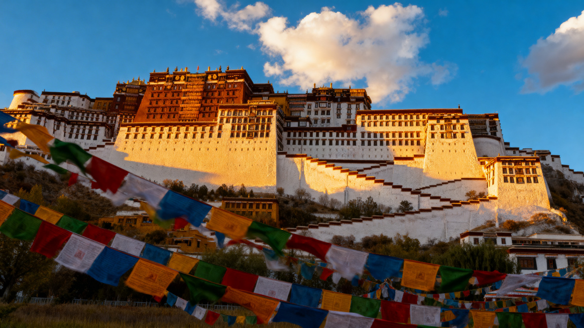 专业旅行摄影风格，西藏布达拉宫全景，金色夕阳柔和照射在白色宫墙上，天空是澄澈的蓝天白云，前景处五彩经幡正随风飘扬，画面层次丰富，氛围神圣治愈，超高清画质，细节真实细腻预览效果