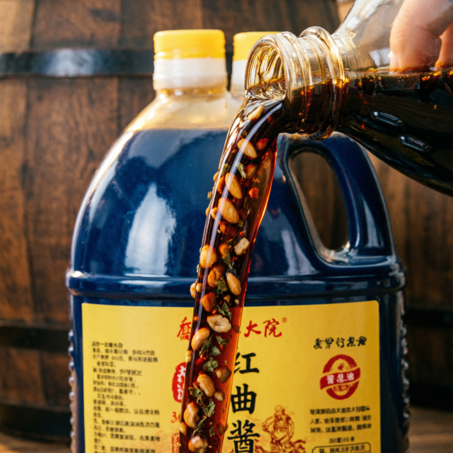 乔家大院红曲酱油商品主图，重点展示五仁清香卖点，参考图配色为深蓝、黄、红，1:1正方形，适配淘宝天猫平台，瓶身倒出酱油展示细节，传统古法酿造风格预览效果