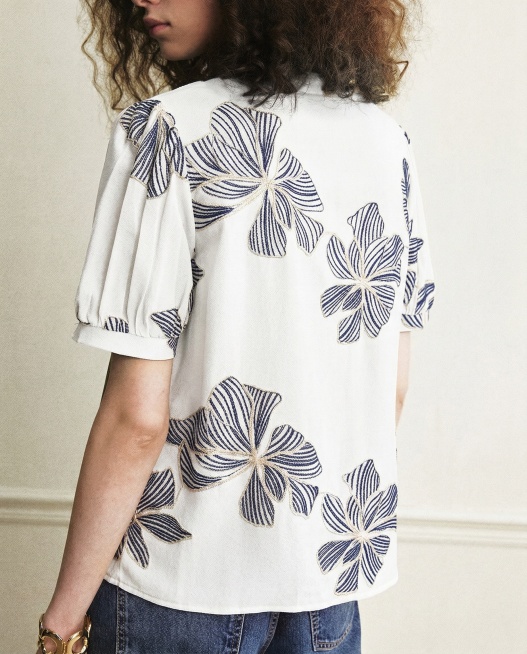 将这件衣服的底色从军绿色改成白色，将花朵内部的浅杏色线条改成藏青色，保持花朵边缘的米白色线条不变，整体衣服款式和刺绣结构不变预览效果