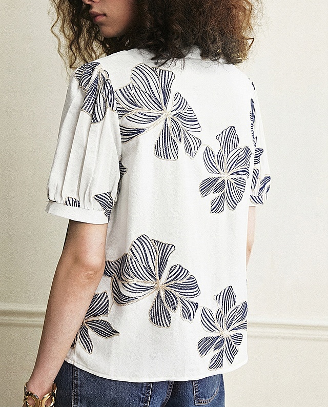 将这件衣服的底色从军绿色改成白色，将花朵内部的浅杏色线条改成藏青色，保持花朵边缘的米白色线条不变，整体衣服款式和刺绣结构不变