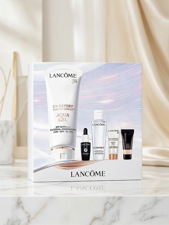 更换符合高端兰蔻护肤礼盒的背景，保持礼盒包装所有形状、品牌文字和Logo完全不变，只替换背景。生成轻奢优雅风格，礼盒放在浅色大理石台面上，背景为米白与香槟金色调，柔和自然漫射光线，精致高光突出包装质感，整体氛围高级干净通透，保留礼盒原有位置和细节不变