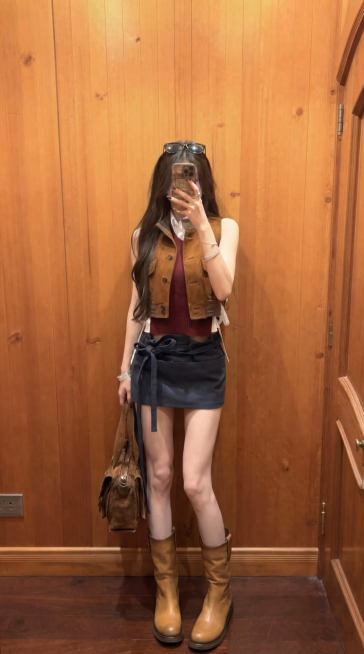 固定镜头，人物一只手举着手机对镜自拍，手机不要放下来。另一只手撩一下头发，动作幅度小一点，然后微微侧身又回正，然后自然的动一下，做动作展示穿搭，动作流畅自然，整体自然真实，模特对镜自拍展示穿搭的过程，预览效果