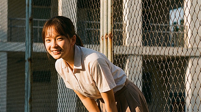 将线稿完善为摄影写实风格，人物保持原有的动作姿态和角度不变，晴朗的初夏下午5点，阳光从正面照射在女生身上，整体画面具有纪实摄影的质感和光影层次