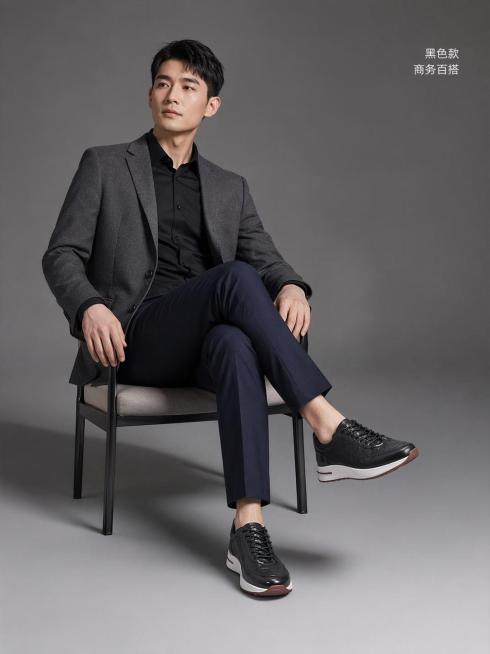 [第7屏] 黑色款模特棚拍展示-男士真皮休闲运动鞋商务穿搭效果。本屏使用【图2】作为黑色鞋子主体参考。
[氛围/风格] 简洁棚拍风，高级灰背景，商务休闲质感。
[元素布局] 亚洲男性模特穿着黑色鞋子，预览效果