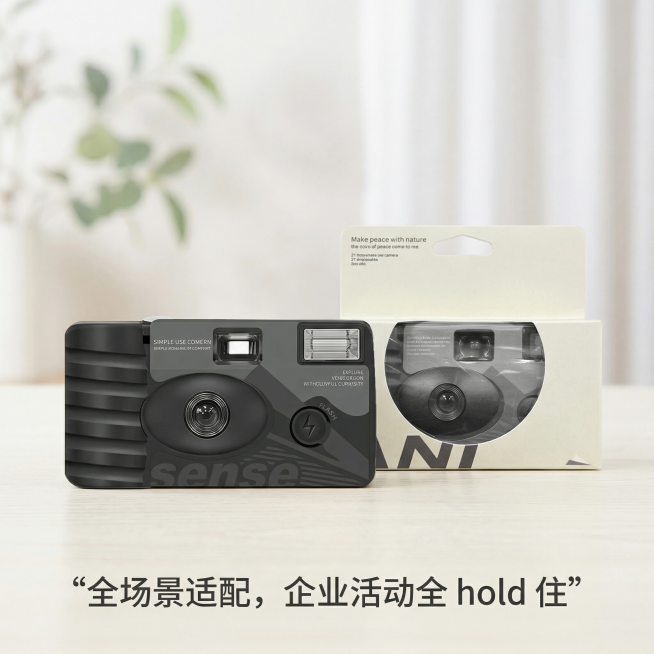 画面主体是用户上传的这款可定制一次性胶片相机，相机和它的包装盒都保持原样，放在米白色的木质桌面上，不悬空。背景是柔和的浅色系室内环境，有模糊的绿植和白色的窗帘，没有黑色、灰色和棕色，背景完全虚化，重点预览效果