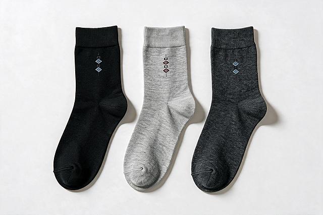 参考第三张图的SKU展示风格，将第一张图的三只袜子整理为标准SKU颜色分类图：三只袜子水平等距排成一排，大小一致，形状平整对称，袜口朝上袜头朝下，角度姿态与参考图一致，间距均匀整齐。从左到右颜色：黑色、浅麻灰色、深麻灰色。完整保留每只袜子原生针织纱线纹路、织物颗粒、原有菱形印花图案，材质质感完全沿用实拍素材，不重新绘制袜子，只匹配环境光线，真实实拍感，禁止过度修图。纯白色背景，柔和均匀顶光，袜子下方有自然柔和投影阴影，整体明亮通透有质感。