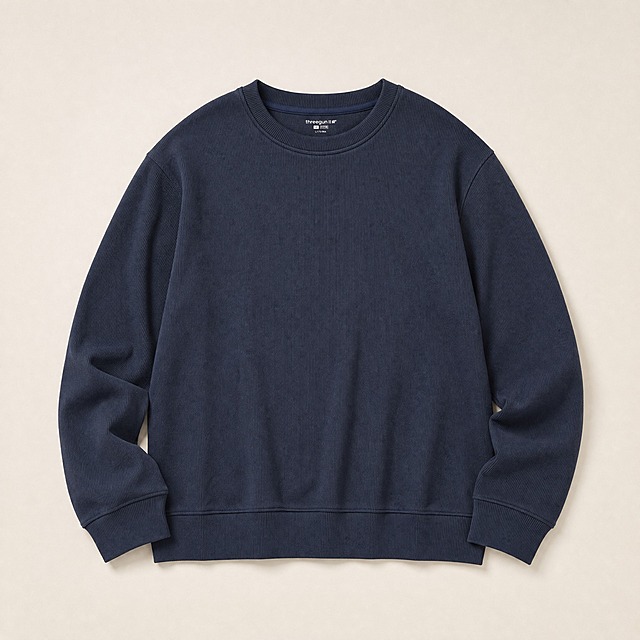[主图-3] 产品平铺图，展示衣服全貌版型。
[统一基调] 风格=休闲简约高级商业摄影；背景主色=浅米灰暖调场景；标题字色=深炭灰；辅助字色=中暖灰；强调色=暖驼色；字体=现代无衬线粗体（标题）+ 简洁无衬线体（正文）；组件=圆角浅底信息卡、细线引线；整体硬朗休闲氛围。
[画面] 藏青色松绒棉圆领男衫正面平铺展示，衣服平整舒展，圆领、长袖、罗纹袖口、下摆罗纹结构完整呈现，可轻微立体折叠增加层次感。背景为浅米白或浅暖灰干净背景，衣服下方有柔和自然的接触阴影，不悬浮。产品主体占画面约65%，居中展示。
[光影质感] 商业摄影质感，均匀柔和顶光，面料罗纹纹理清晰，颜色纯正，阴影自然过渡，体现版型规整和面料质感。
[配色] 主色藏青深蓝，背景浅米白暖灰，整体干净简洁，突出产品本身。
[文字版式] 可在角落加极小品牌标识或产品名缩写，不抢主体；以产品平铺展示为主，不添加大量文案。
[输出要求] 比例1:1，2048px*2048px，2K分辨率，产品平整清晰，颜色准确；负向提示：避免变形、错字、模糊、杂乱、水印、平台Logo、抗菌抑菌除湿发热蓄热等功能性词汇、衣服褶皱过多、版型失真。