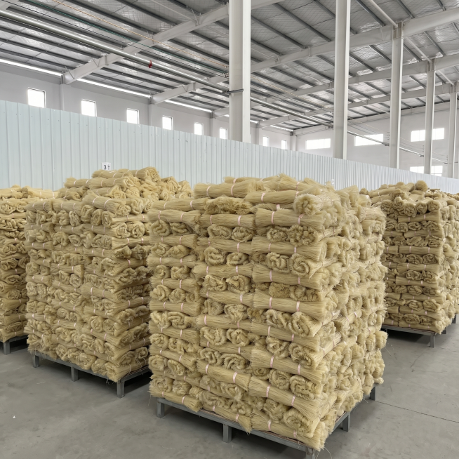 [主图 1] 工厂实力展示首图：大量捆扎的米黄色粉丝整齐堆叠在现代化厂房内，展现规模化生产实力；[氛围风格] 高级工业实拍风格，干净明亮的专业工厂环境；[画质] 商业摄影质感、光线柔和通透、产品清晰真预览效果