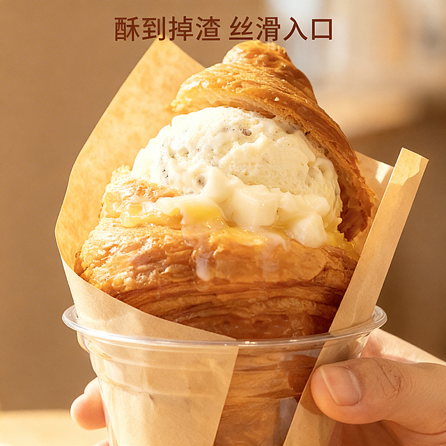 [垫图] https://gdesign-dam-hz.dancf.com/35973360354843773/3424658c1fcc459a85e51eca9a03ea61.png
[主图主题] 豆花冰激凌可颂纹理细节展示
[氛围/风格] 温暖治愈质感风，自然阳光漫射
[画面元素] 微距特写聚焦可颂酥脆外皮和冰激凌绵密纹理，可颂层次分明，黄油光泽油润诱人，豆花冰激凌带有细腻颗粒感，少许融化的冰淇淋顺着可颂流下来，动态感十足，背景虚化，只保留模糊暖调氛围，全屏无边框
[配色色系] 主色调：焦金黄、奶白；点缀色：浅棕背景
[视角构图] 微距特写，主体占据80%画面，突出纹理细节
[文字版式] 顶部小字文案 "酥到掉渣 丝滑入口"，字体纤细，深棕色，不遮挡主体细节，排版简约
[比例分辨率] 2k 分辨率
