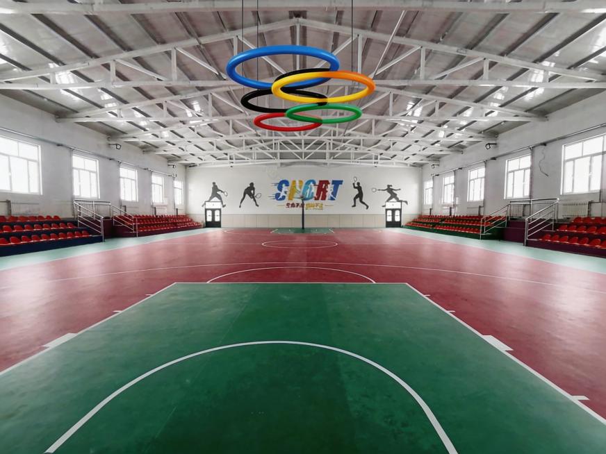 将图2中的彩色五环吊顶添加到图1的篮球馆吊顶位置，保持整体场景协调自然预览效果