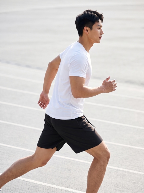 保持模特的身材、五官、发型、跑步姿势、黑色短裤和跑道背景都不变，给模特的上半身添加一件简洁的白色运动短袖上衣，风格和整体画面自然融合，保持全身展示构图不变，画质依旧高清写实，光影自然衔接预览效果