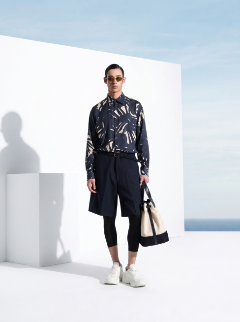 参考第一张图的场景和构图，将模特替换为第二张图的模特，保留简约白色几何背景和海景蓝天，保持高端男装广告大片风格，整体光影和构图与参考图一致预览效果