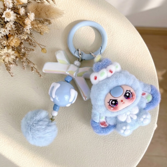 将这张毛绒挂件商品的背景换成奶油风ins风格，保持主体挂件商品结构和颜色完全不变，只更换背景。让商品居中放置，商品大小比例合适不要太小。背景为奶白色肌理感桌面，左上角点缀干燥花装饰，柔和自然光，光影温预览效果